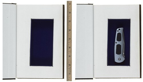 A folding knife displayed in a velvet lined box, relating to film props and set design.