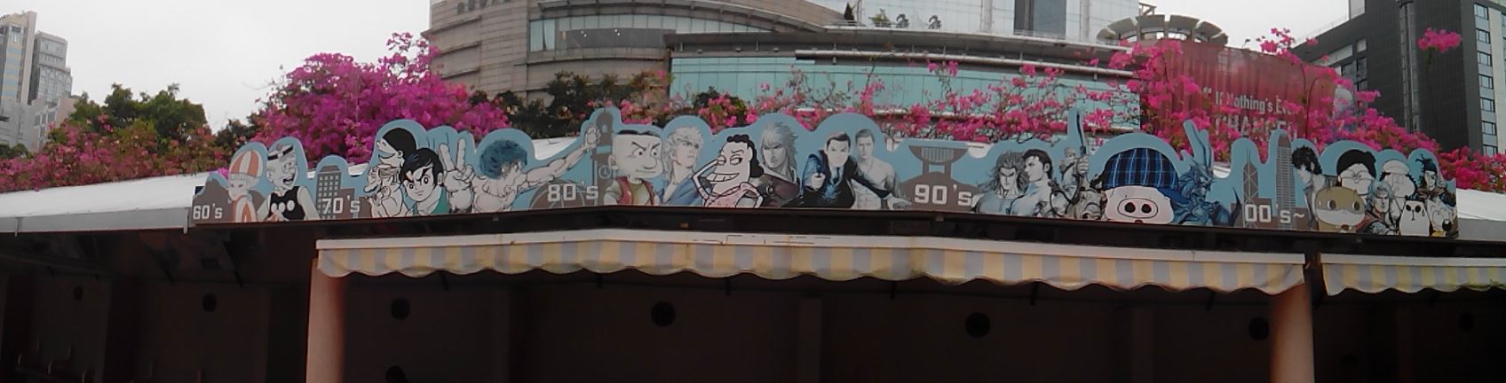 A building exterior displays a vibrant mural celebrating pop culture icons from the 70s, 80s and 90s.